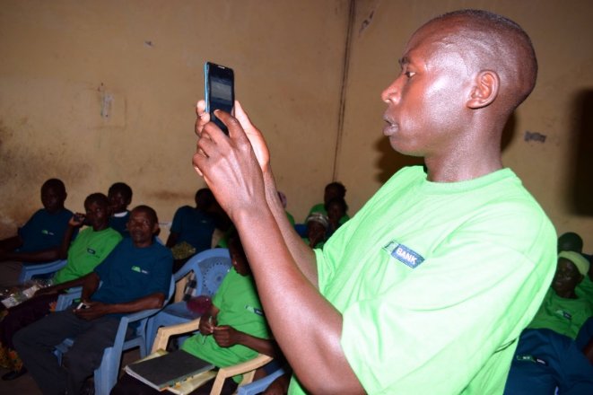 Nchama Samuel, a member of Kenya Group (one of the Chama Solutions Group) demonstrating to members how to borrow and approve loans through the KCB Chama Solution Digital Platform.
