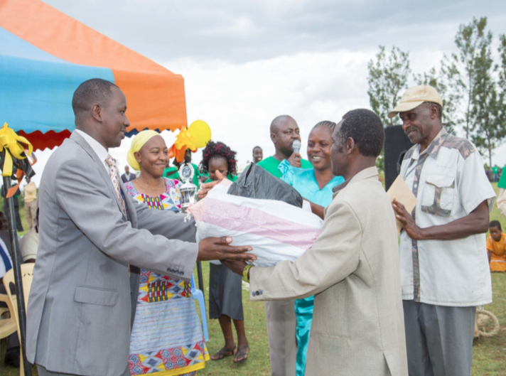  Rebwi Farmers Co-operative Chairperson (Rioba), Treasurer (Kohera) receiving an award from the Kuria East Sub-County Commissioner (Koech) during the International Day for the Eradication of Poverty (IDEP) on October 17th, 2016. Looking on is Nuru Kenya Country Director, Pauline Wambeti