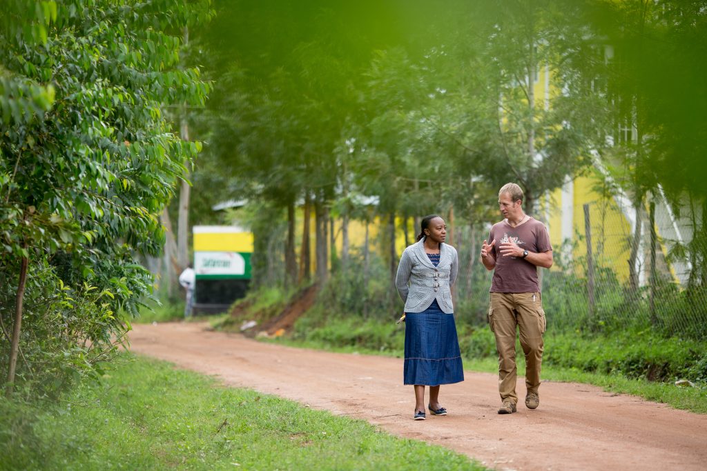 two people walking down a road - Nuru Kenya leader and Nuru International founder