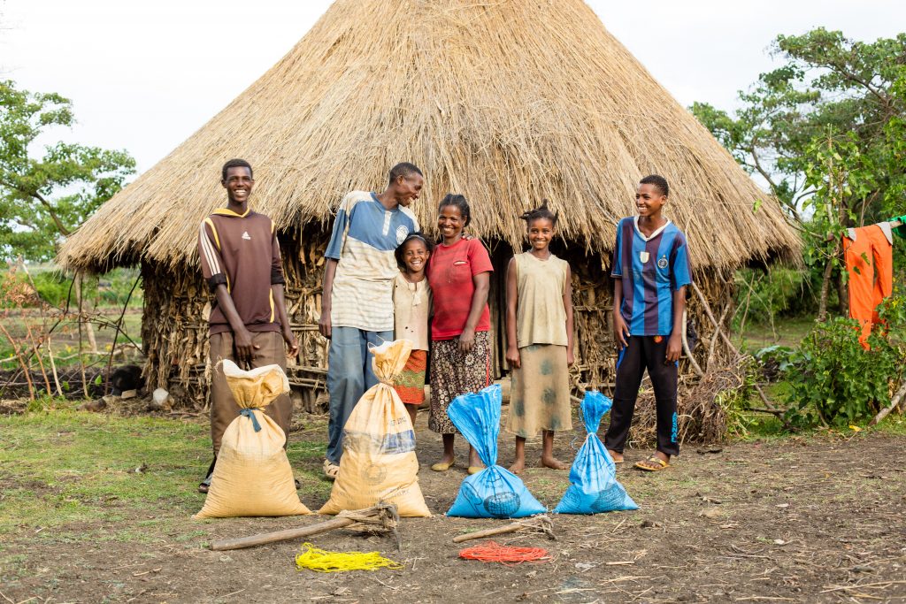 group of people standing in front of home in Ethiopia