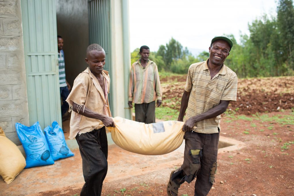 farmers carrying bags together