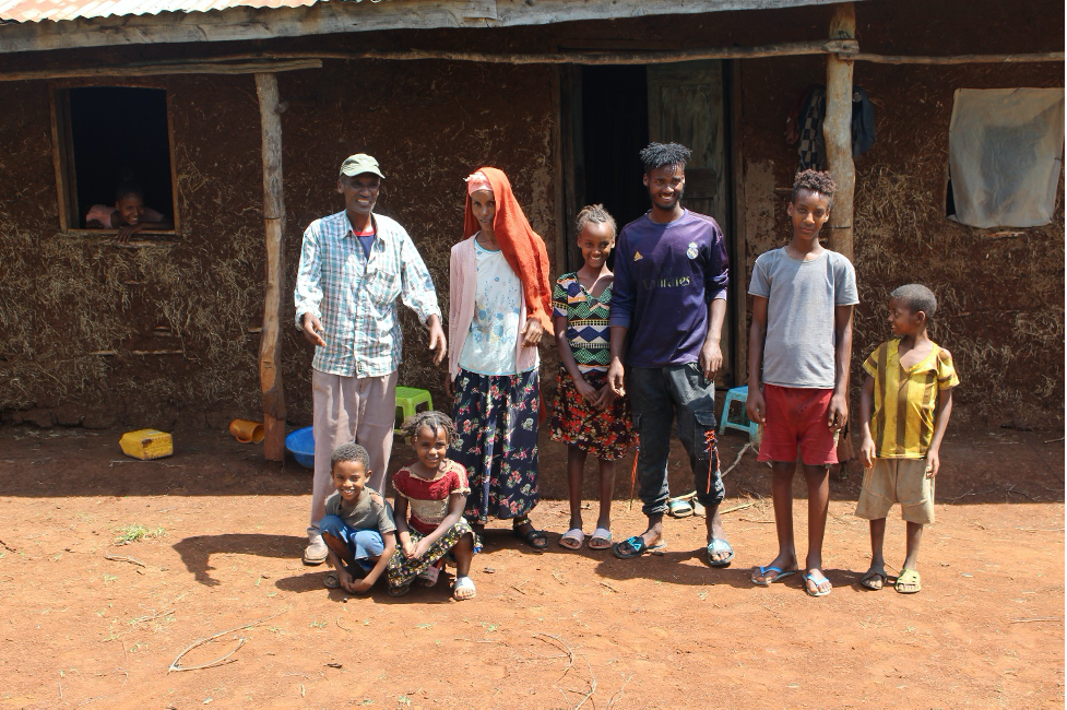 farmer family standing together outside of a building