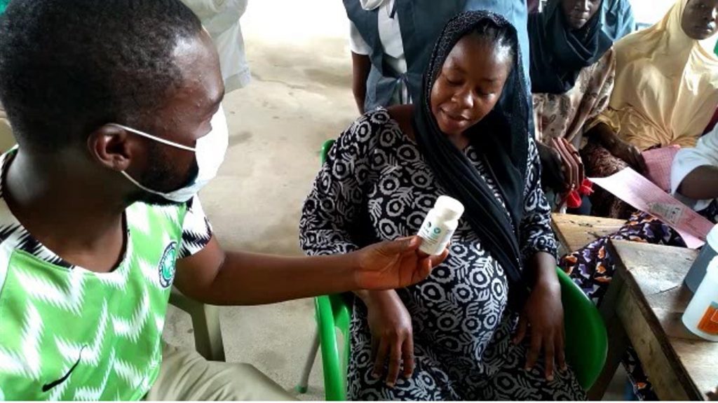 pregnant woman being receiving a bottle of vitamins