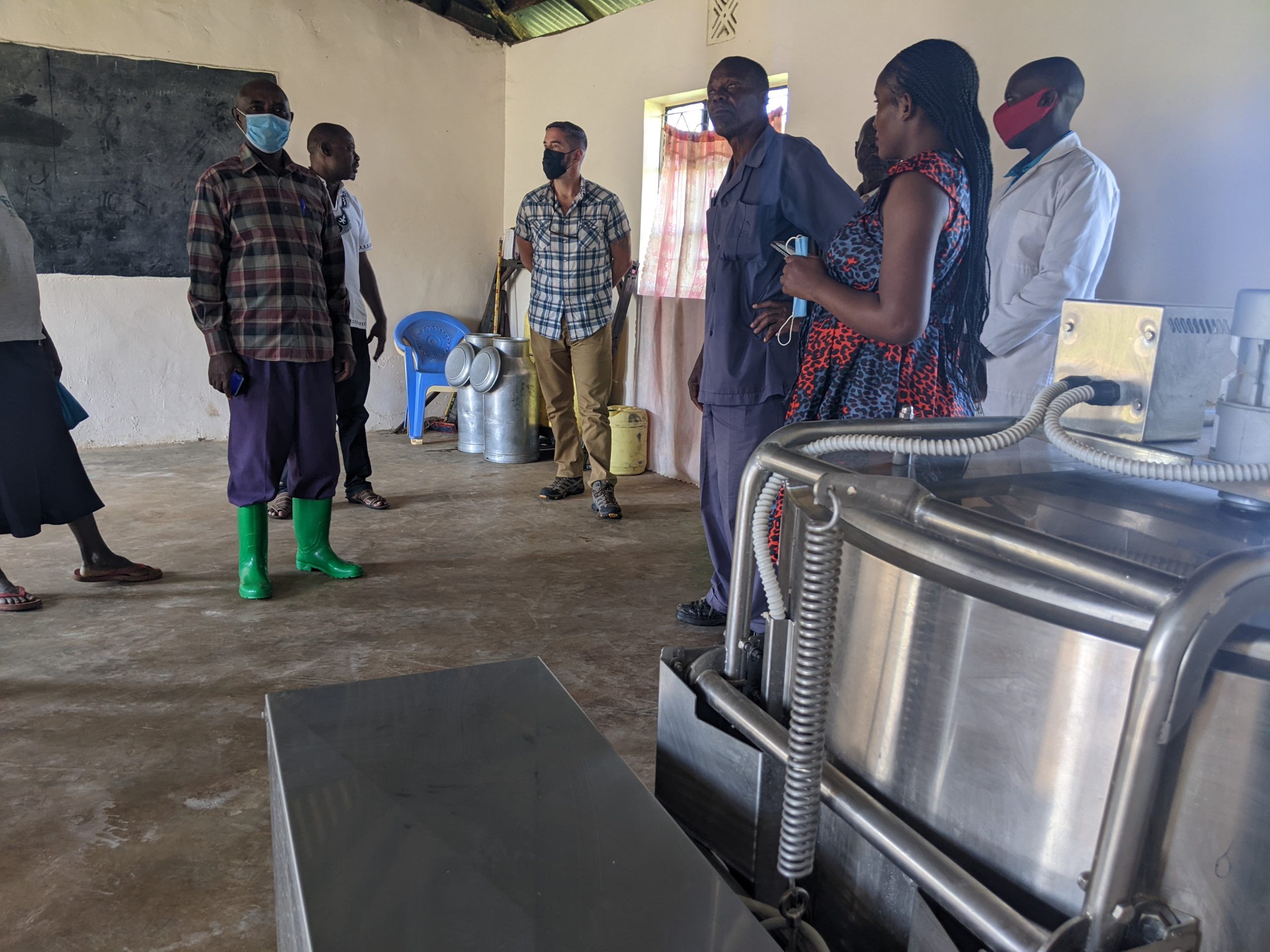 group of people in a milk cooler facility that is supporting farmer resilience to shocks, including climate-related shocks