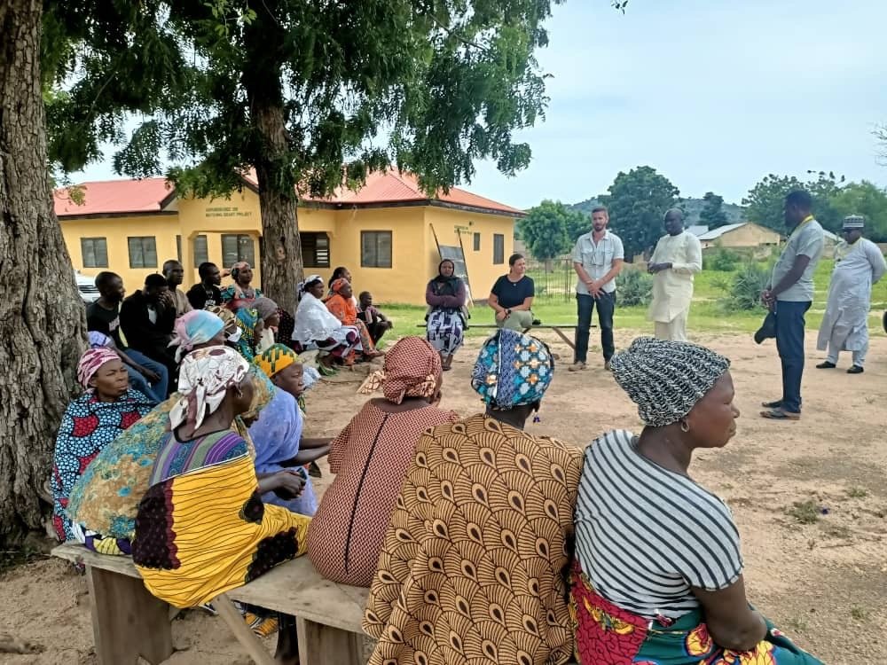 community members in Nigeria sitting outside 