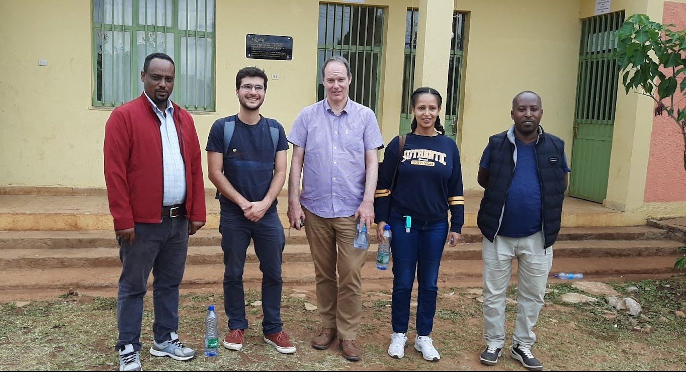 Five individuals – Nuru Ethiopia staff and AMEA network members – stand in a line in front of a building.