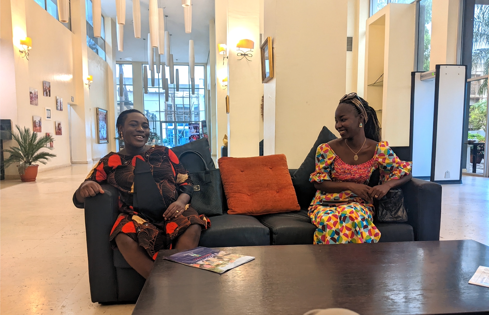 two women sitting on a couch and talking to each other