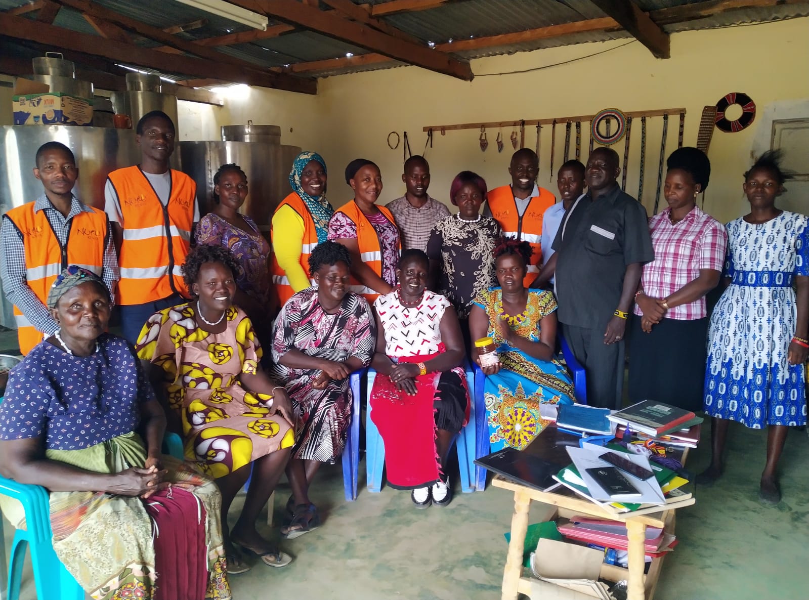 Women beekeepers gathered with Nuru Kenya staff members for a photo 
