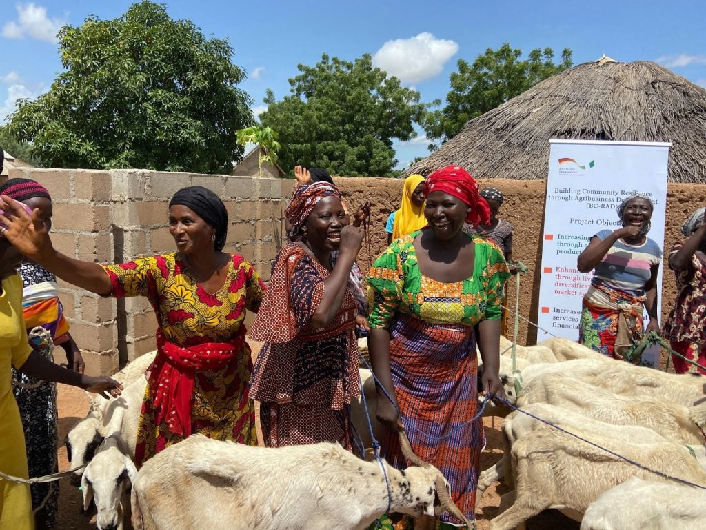group of women standing outside with livestock and smiling