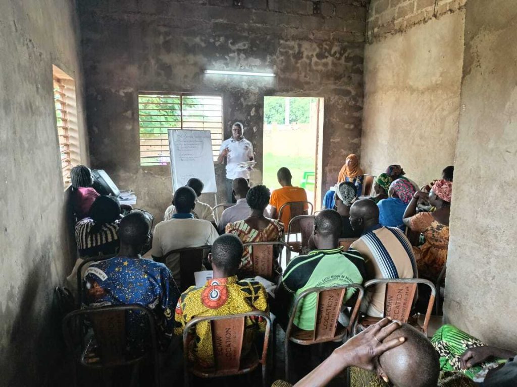 group of people meeting together in a classroom in Burkina Faso for mobile money financial training