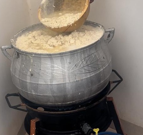 boiling pot of soy milk with curds being produced on top 