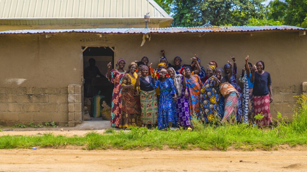 group of women smiling and laughing outside a building in northeast Nigeria