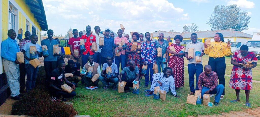 group of people from Baringo County sitting outside and smiling at the camera with seeds 