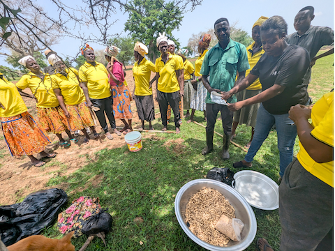 group of people stand together in a circle during farmer training with Nuru Ghana