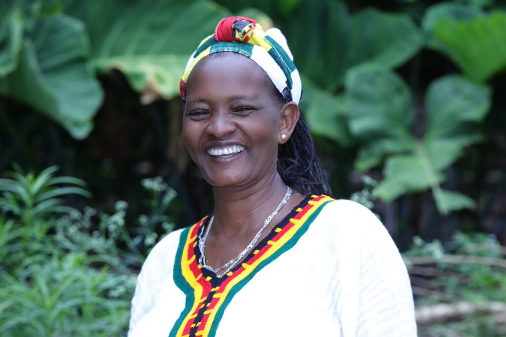 woman in Ethiopia standing outside and smiling at the camera