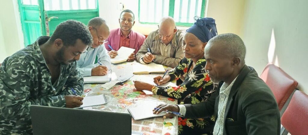 group of people huddled around a table together during a meeting 