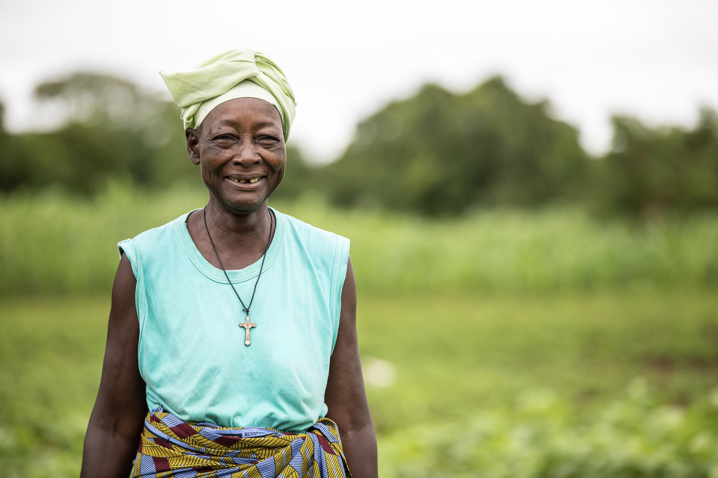 woman standing in a field and smiling at the camera